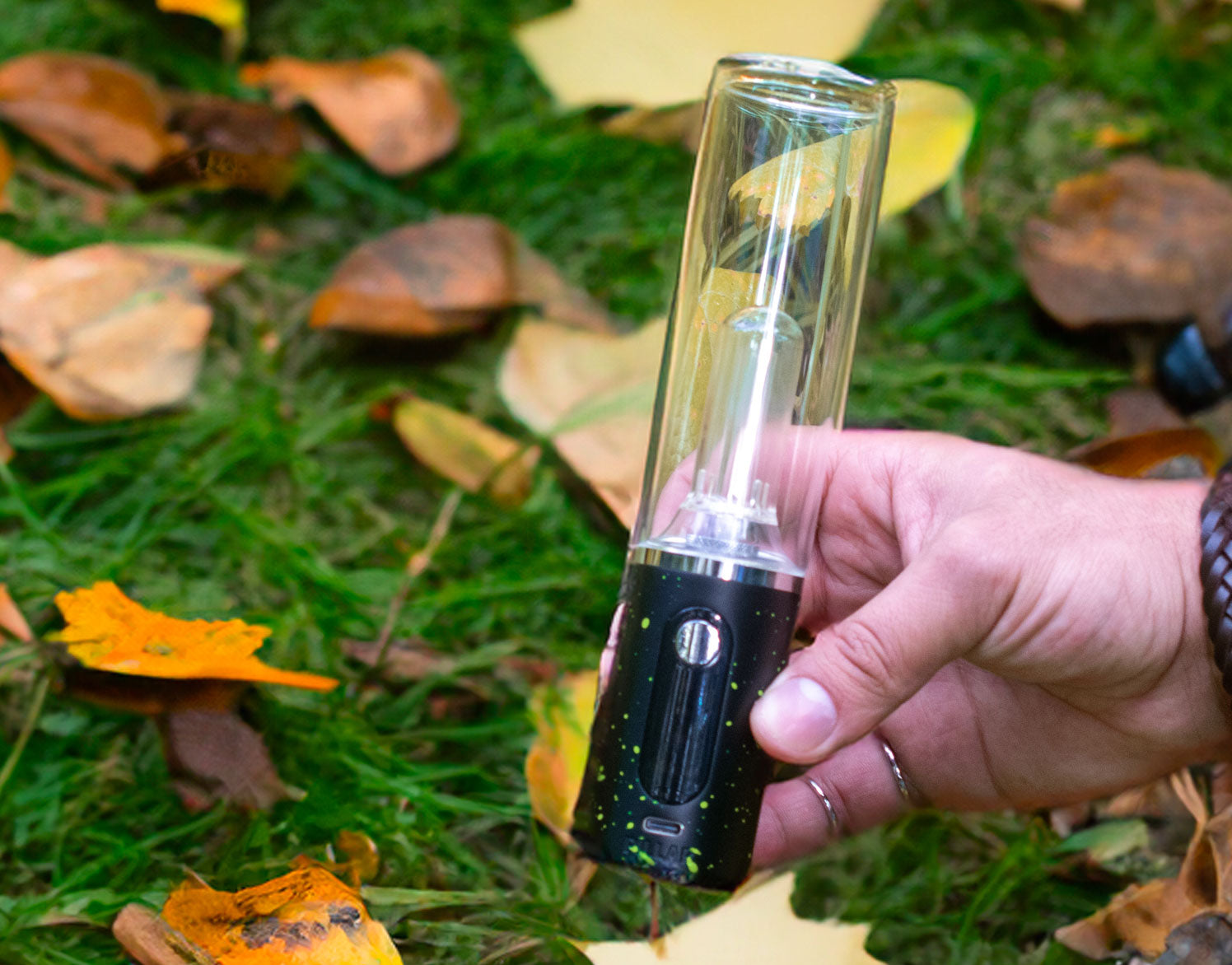 man holding the Wulf Pillar with fall leaves and grass in background